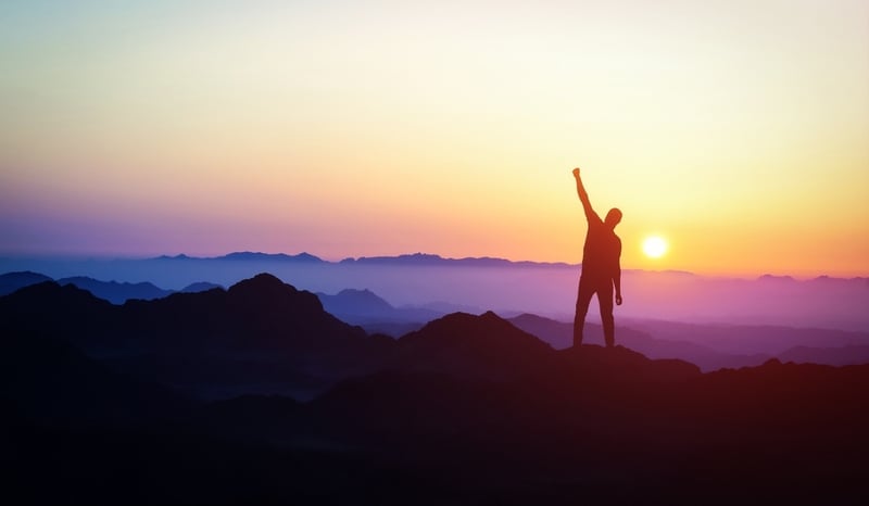 Image for Man silhouette stand on peak of moutain with hand up. Success and motivation. Mountains landscape with sunset as perfect driven leadership concept stock photo