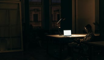 Man in dark room with light on working as shadow AI concept stock image