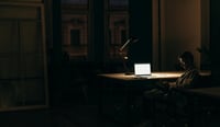 Man in dark room with light on working as shadow AI concept stock image