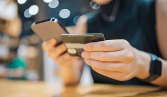 GenZ paying debt and financial loan with her mobile phone and credit card as subscription acquisition cost concept stock photo