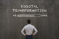 Man looking up at Digital transformation loading up to 100% sign 