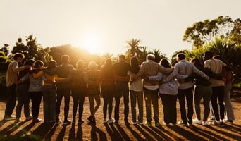 Back view of happy multigenerational people having fun in a public park during sunset time - Community and support concept stock photo