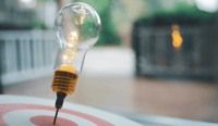 Light bulb with arrow of darts on dart board. Concept of finding problem solving or business development, key to success. stock photo