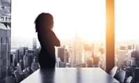 Business woman looking over city contemplating how to turn corporate purpose into impact