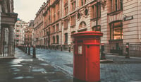 Iconic red post box stands on a deserted london street in the morning stock photo