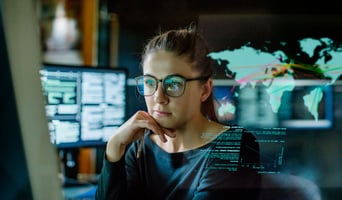 Woman sat at a computer to signify using AI to discover crime stock photo