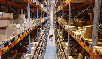 High angle view of a warehouse manager walking with foremen checking stock on racks as sustainable supply chain change management concept stock photo