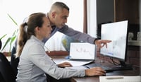 Businesspeople working in the office on stock market exchange data using desktop computer and digital tablet or public sector officials reviewing the spending review on computer conceptstock photo