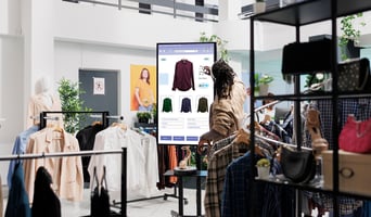 African american man looks at clothes as phygital retail experience concept stock photo