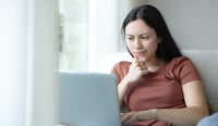 Suspicious woman checking laptop content at home stock photo as subscriptions concept.jpg