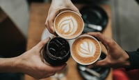 Three coffees cheersing with hands to signify coffee shop customer experience employee experience at global coffee chain concept