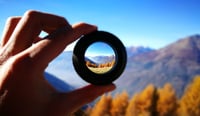 Mountains Seen Through Lens Being Held By Person as purpose by design concept stock photo