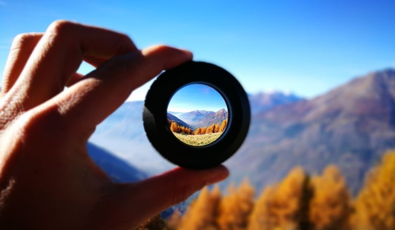 Mountains Seen Through Lens Being Held By Person as purpose by design concept stock photo